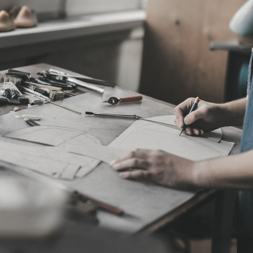 DESIGNER DRAWS 1812 SHOES AT DESK