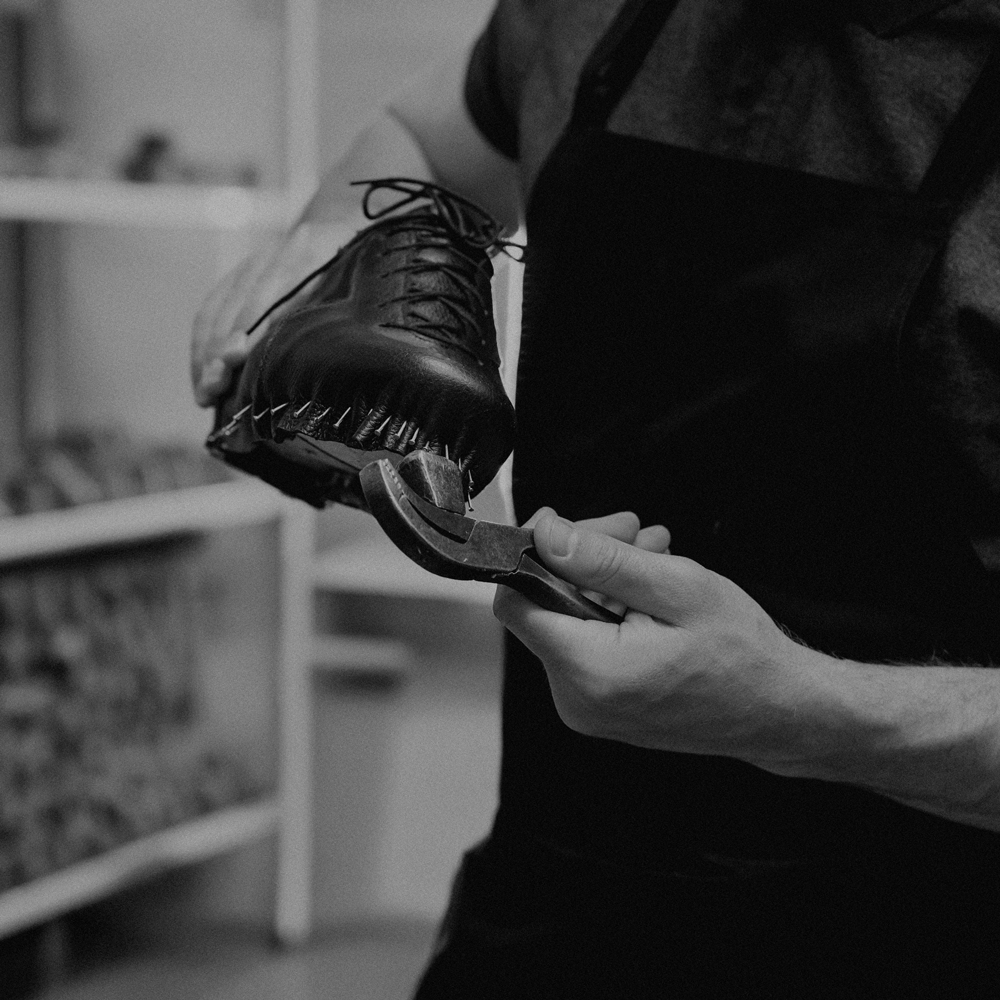 At the heart of English shoemaking is a dedication to quality materials., man making leather shoe
