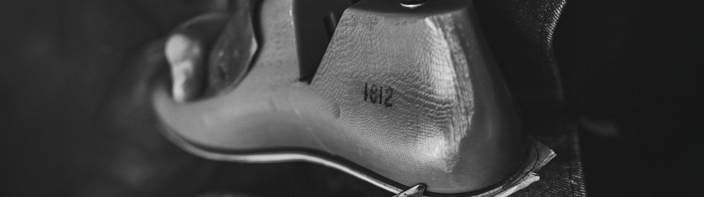 TOE AREA OF A SNEAKER UPPER ON A LAST, BLACK AND WHITE, WIDE CROP
