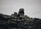 TARLAIR. LAYERED ROCK STACKS UNDER A PALE SKY, IN BLACK AND WHITE